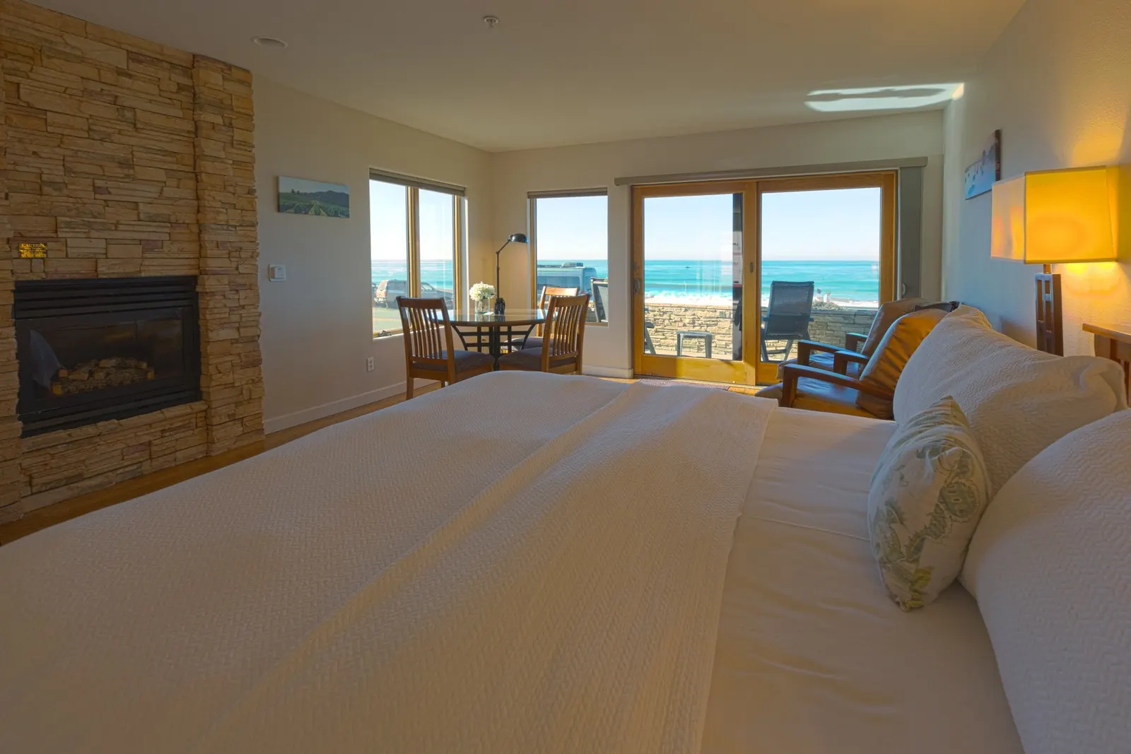 Hotel suite with a king bed and glass doors facing the ocean